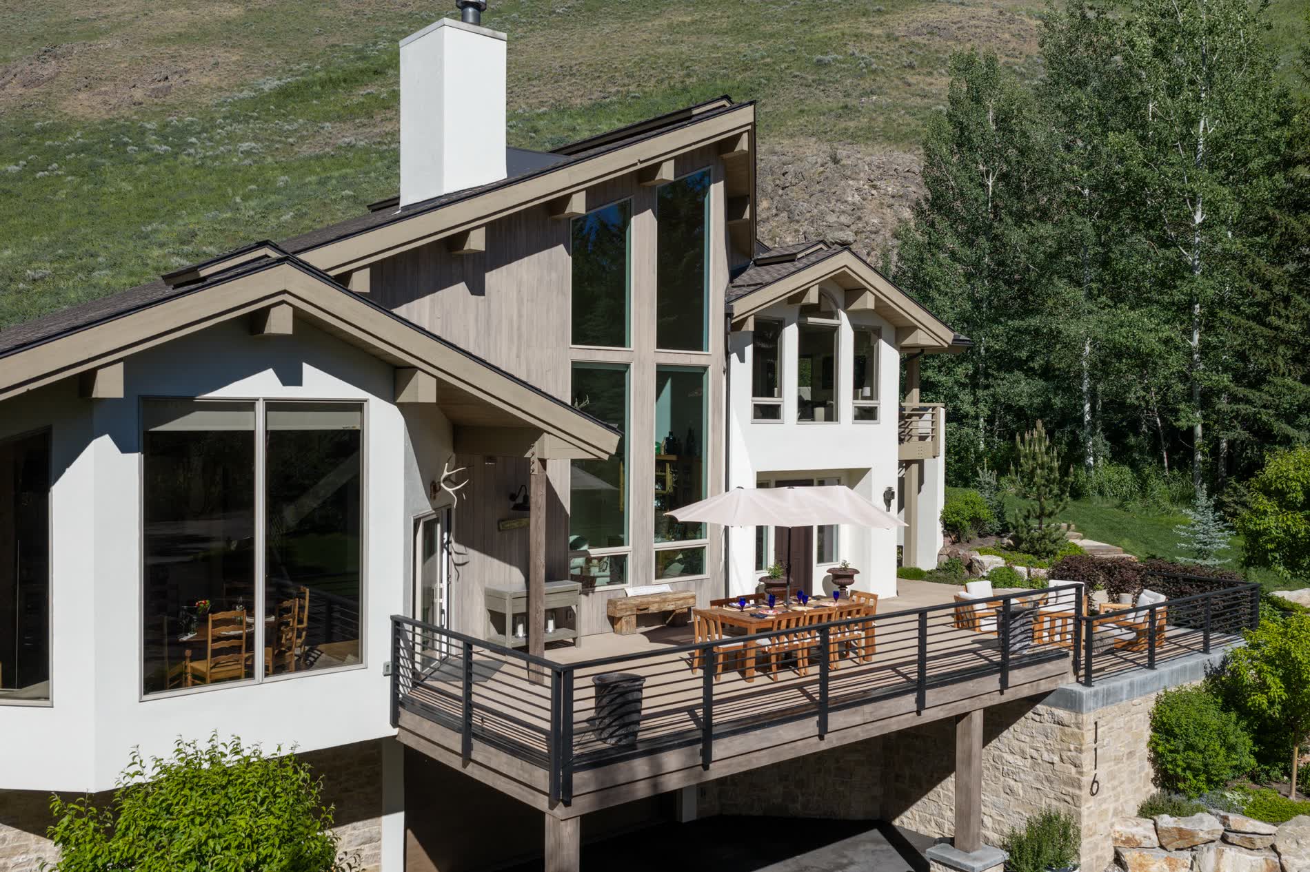 Aerial view of the residence and its terraces set against the wooded hillside