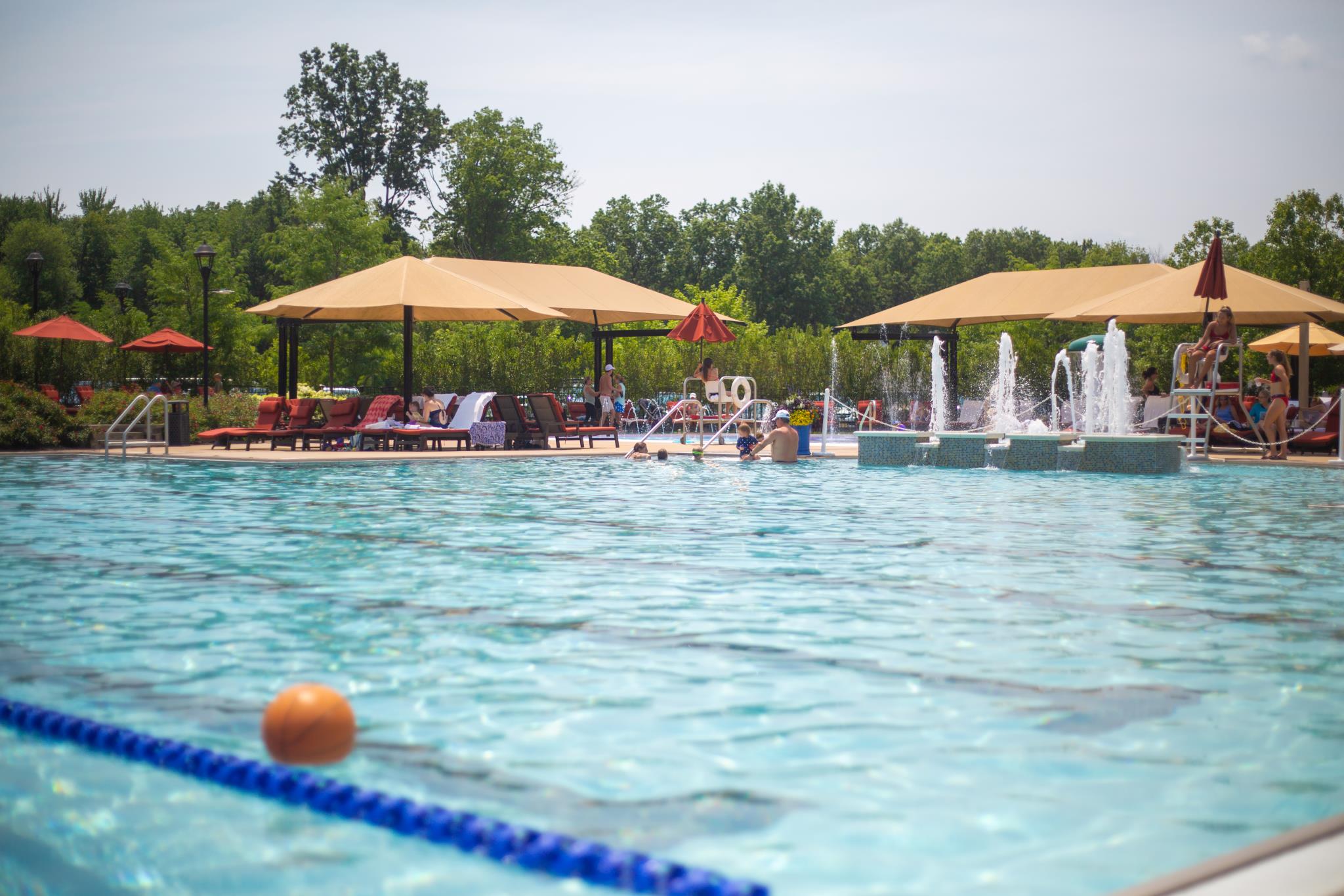 Fiddler's Elbow Country Club pool complex with fountains, umbrellas, and loungers on a summer day
